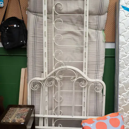 single foam mattress and white painted metal bed frame