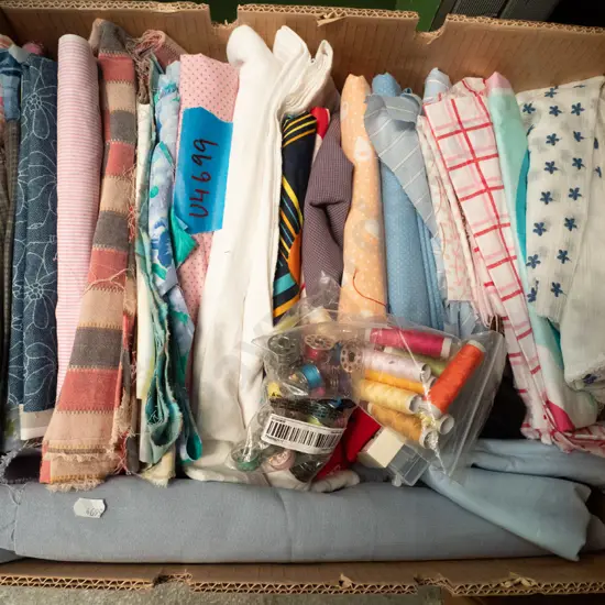 box of fabric pieces and cotton thread