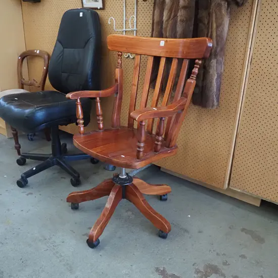 large wooden swivel armchair on casters