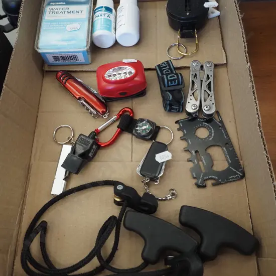 box of pocket knives, water treatment bottles, multi tools etc