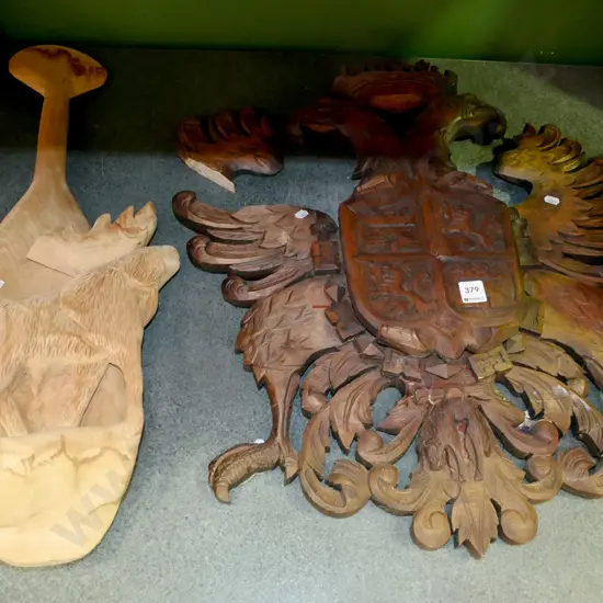 heavily carved wooden shield with coat of arms (piece broken off) and a carved wooden souvenir paddle
