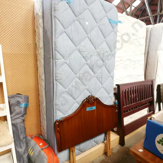 single bed with mismatched  base mattress and mahogany headboard