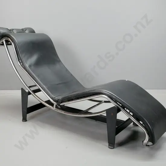 Le Corbusier style chaise longue with black leather upholstered seat on chrome and black painted metal base. Head rest