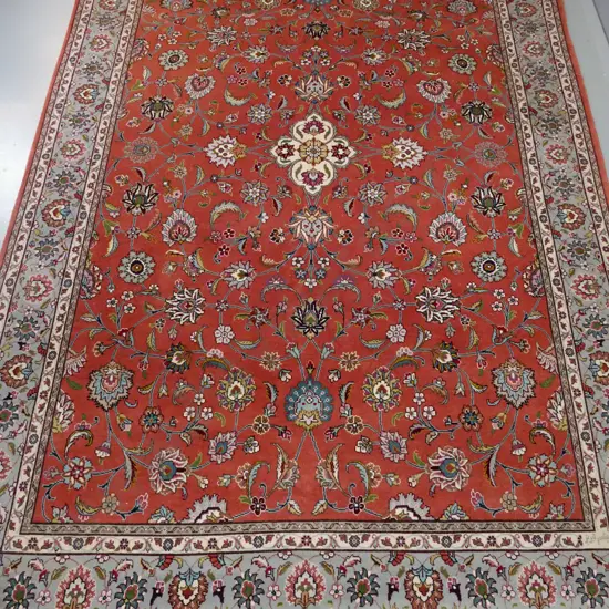 large Persian style wool floor rug with traditional floral motifs - red, grey, blue and ivory - a little fading L3100