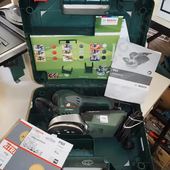 cased Bosch orbital sander with additional discs