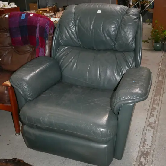 green leather upholstered reclining armchair on casters -wear to leather