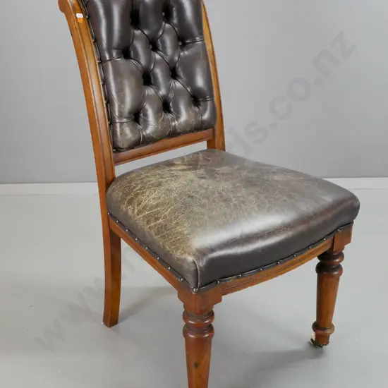 Victorian rimu Cromwellian style chair with deep button leather back, turned front legs, brass crown feet on porcelain