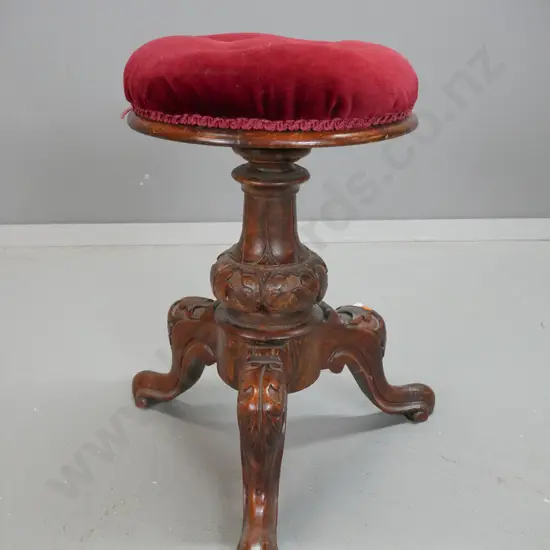 Victorian carved elm piano stool on 3 sweeping carved legs, with buttoned velvet upholstered swivel adjustable seat -