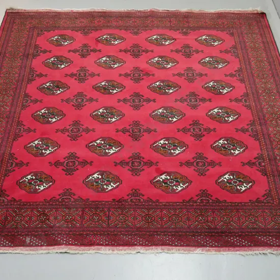 hand knotted wool floor rug - label marked Turkoman - red, black , brown and cream. Some staining. L-1940 W-2000