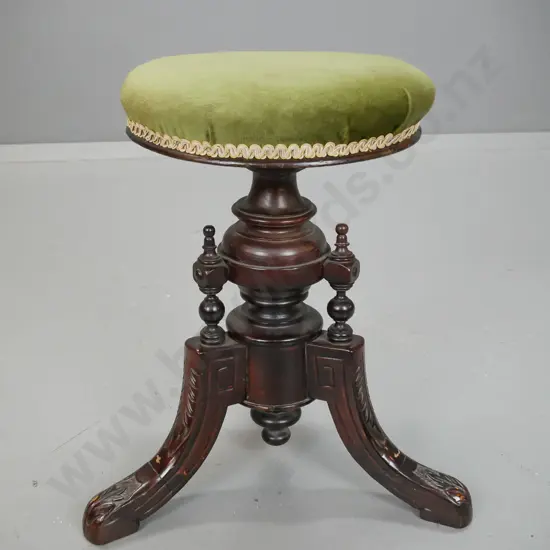 Victorian elm revolving seat piano stool with 3 shaped carved feet, turned supports, green velvet upholstered seat.
