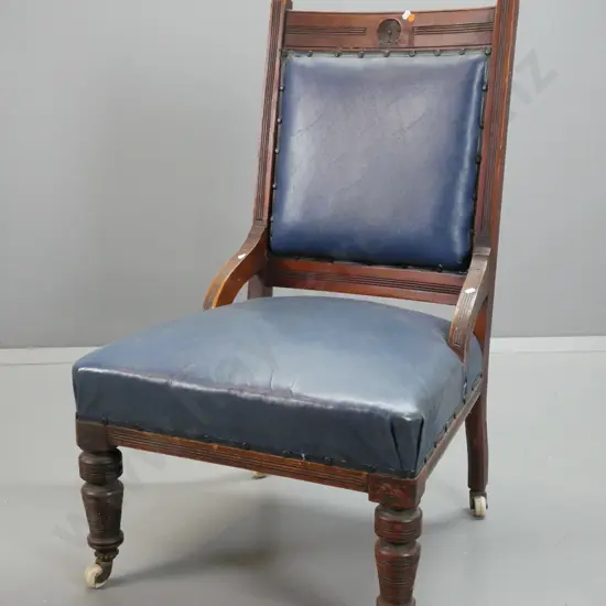 Edwardian walnut lady's chair with fluted uprights, turned legs on porcelain casters, covered in blue vinyl - wear
