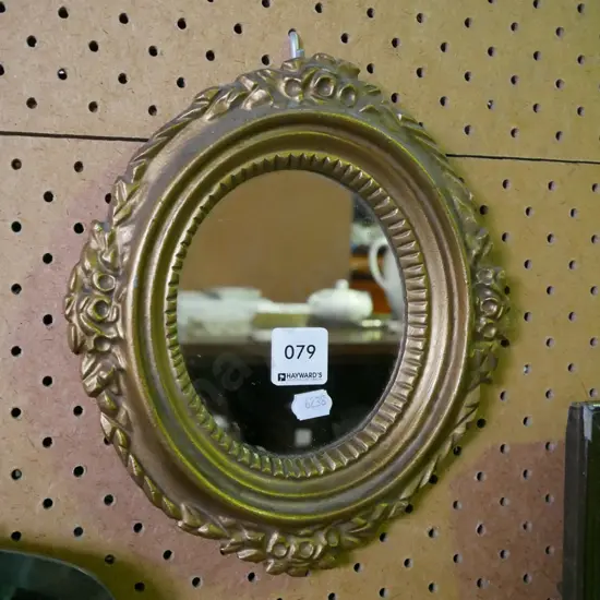 small oval gilt-framed wall mirror
