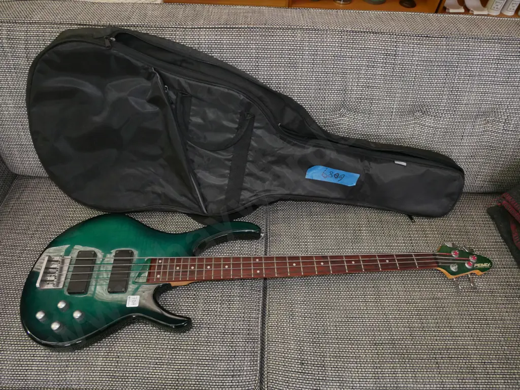 Peavey electric bass guitar with gig bag. One knob loose, needs attention. Image 1++