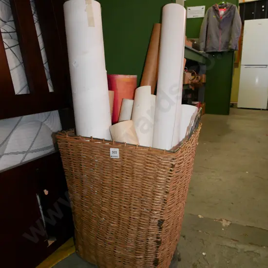 cane basket with cardboard tubes, rolled up prints