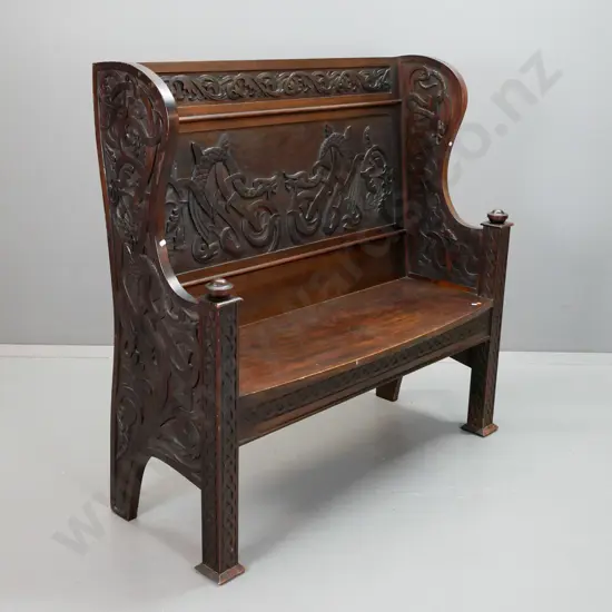 colonial New Zealand stained kauri settle with carved Celtic style dragons and motifs, turned armrest finials, bow-front