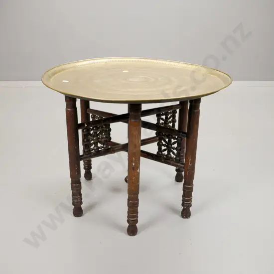 Egyptian? embossed brass tray table on folding beech base with turned bracket decoration. Minor paint flecks H-450 D-580
