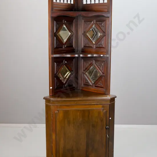 mixed timber corner cupboard with ornately carved top section on more modern base - top has shaped and turned top,
