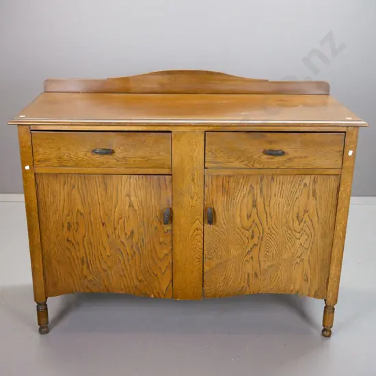 vintage oak 2-door 2-drawer sideboard with shaped back, panelled sides, embossed metal handles. Some water stains on top