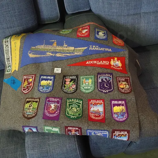 wollen blanket with various tourist badges and pendants