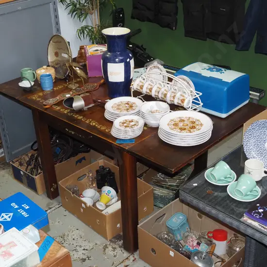 dark stained wooden extending dining table with no chairs and hand painted golden leaves