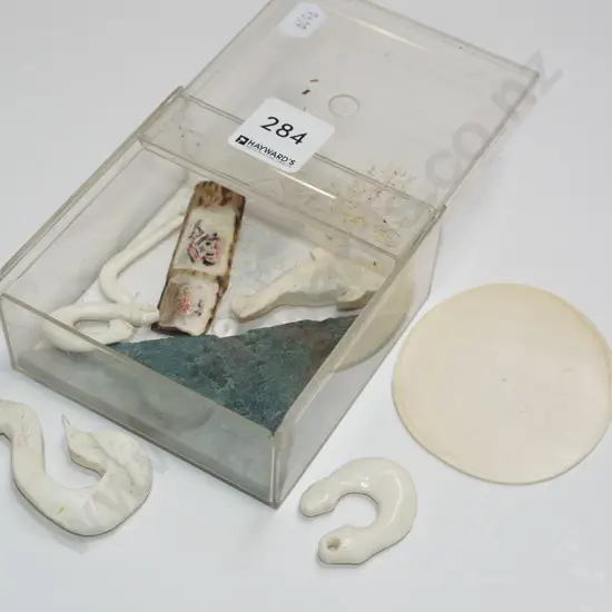 plastic contianer of partially finished bone hooks, piece of jade etc