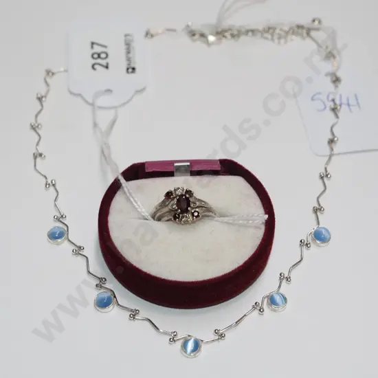 trinity ring with ruby coloured stones (2 stones missing) & a silver necklace with blue coloured stones