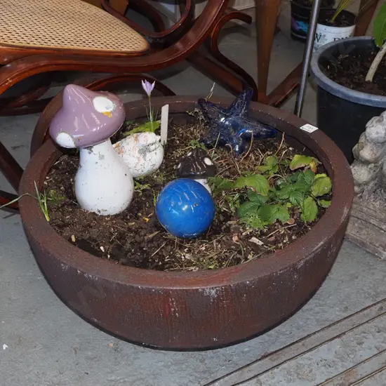 garden planter with plants and ceramic ornaments