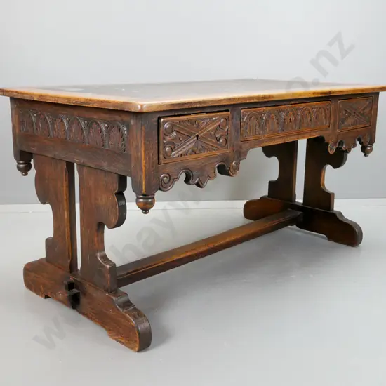 early 19th century European refectory based oak desk with carved lunettes and scroll work on sides and drawer fronts,