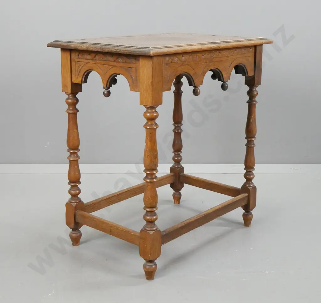 vintage carved oak side table with carved arches to side panels, turned legs, stretcher base, carved lunettes in top. Image 1++