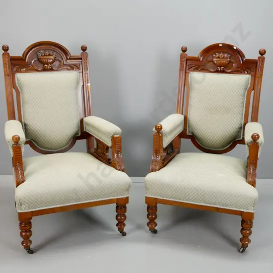 pair of vintage upholstered kauri armchairs with shaped carved back, fluted and foliate carved arms, turned legs - one