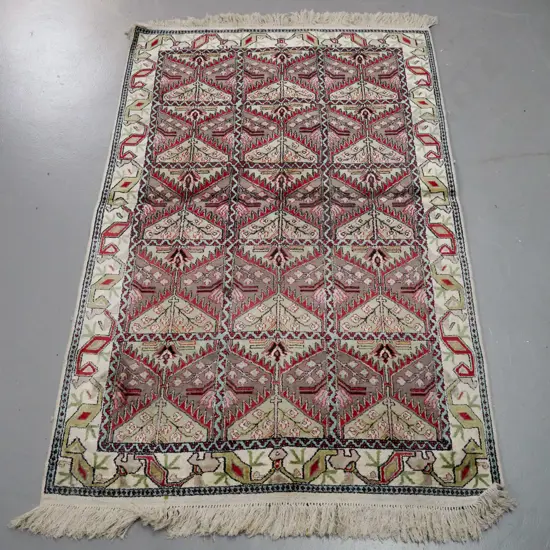 Persian / tribal style floor rug with geometric floral motifs, in faded reds, pinks, greens - a few stains L-1480 W-940