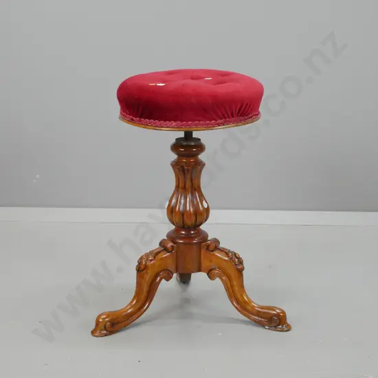 Victorian walnut revolving piano stool w/ shaped fluted column, 3 sweeping cabriole legs with carved floral knees
