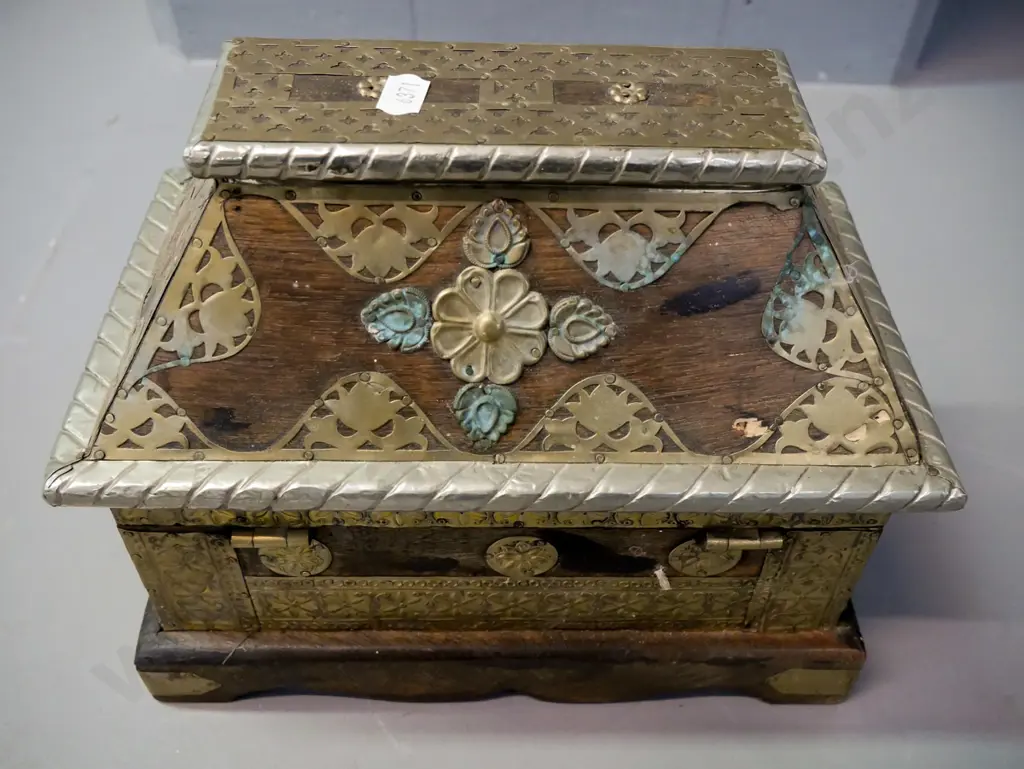 Asian hardwood Sarcophagus-shaped chest with hinged lid, white metal and brass binding, latch & applied decoration. Some Image 1++