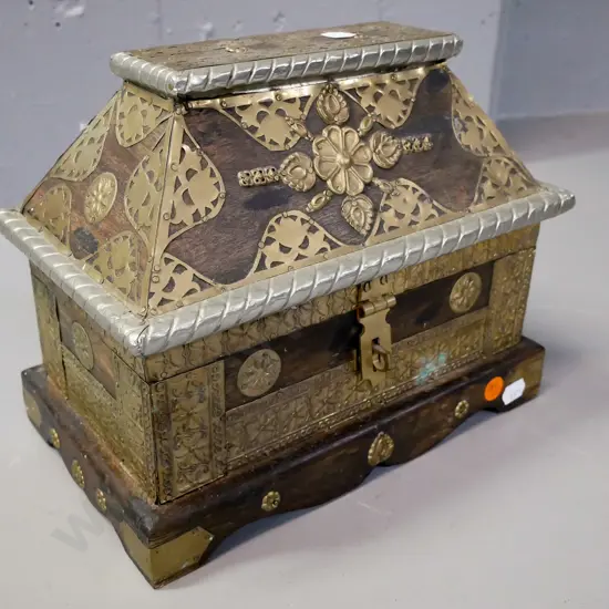 Asian hardwood Sarcophagus-shaped chest with hinged lid, white metal and brass binding, latch & applied decoration. Some