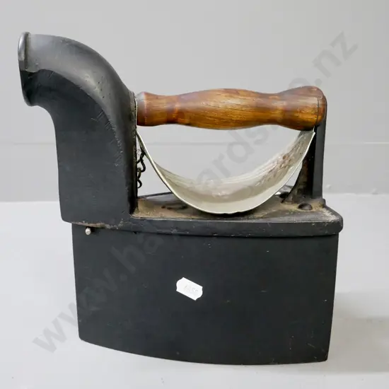 vintage cast metal coal iron w/ white metal heat shield, turned wooden handle, back latch with 'S' motif.