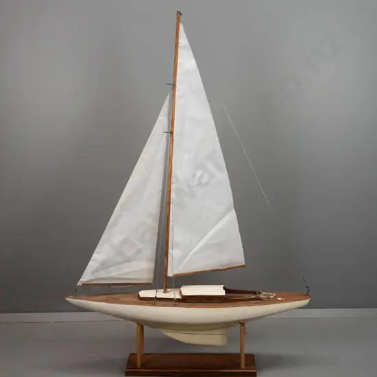 vintage pond yacht on wooden stand, has had sails replaced, one sail boom is broken, some age wear and damage, two