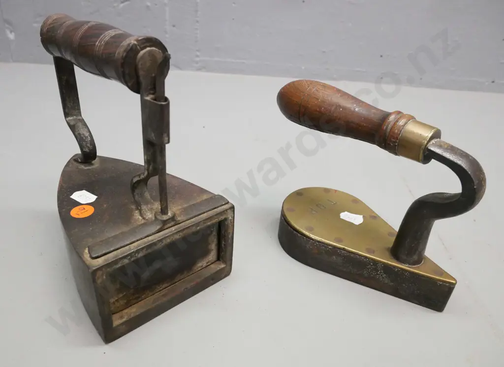 2x vintage cast metal irons with turned wooden handles. 1. Larger w/ coal box, shutter. 2. Small flat iron stamped TDB Image 1++