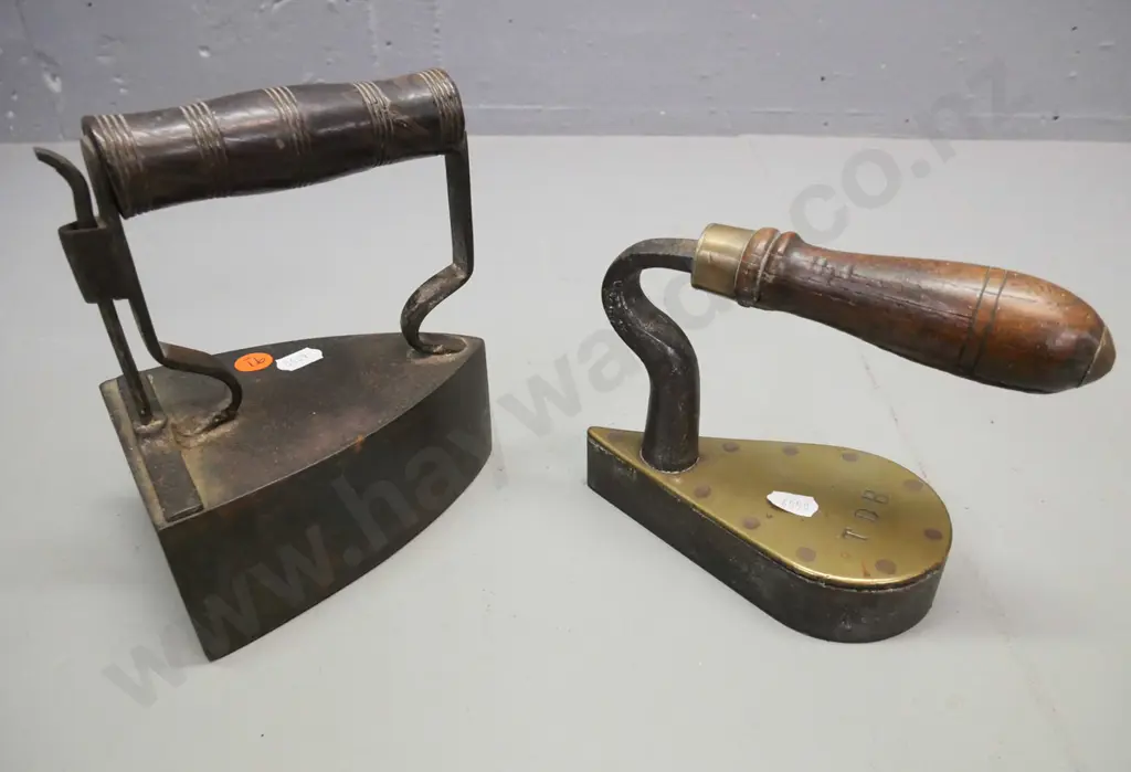 2x vintage cast metal irons with turned wooden handles. 1. Larger w/ coal box, shutter. 2. Small flat iron stamped TDB Image 1++