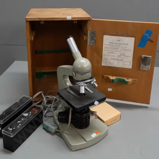 cased Kyowa Tokyo microscope in fitted wood case with 2 extra eyepieces and 1 objective in 2 plastic containers.