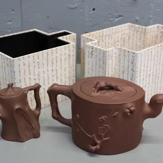 2 Chinese Yixing clay tea pots with applied branch motif decoration and handles, one with fitted faceted box. Larger is