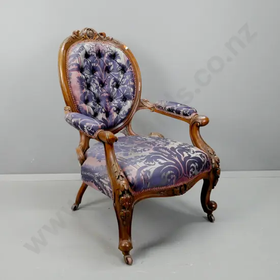 Victorian walnut open-arm gent's chair with carved cameo back, carved knees & cab legs, deep button back, on porcelain