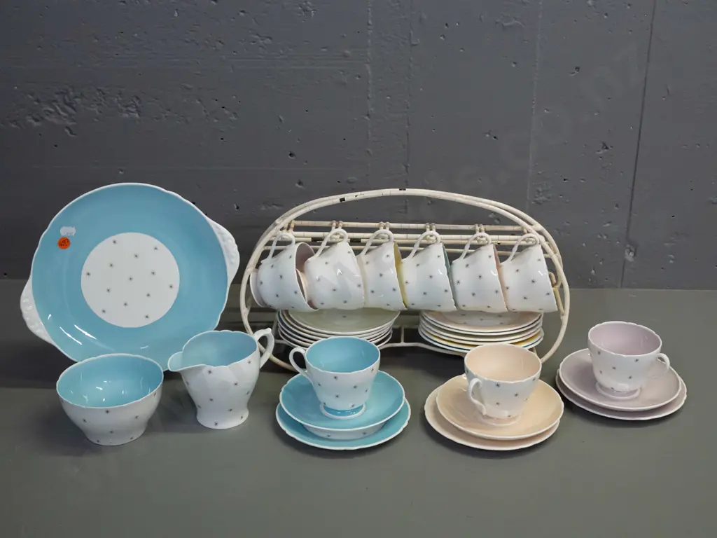 Shelley Pole Star tea ware - 9 trios, cake plate, cream & sugar with a plastic over wire stand. Slight scratch to cake Image 1++