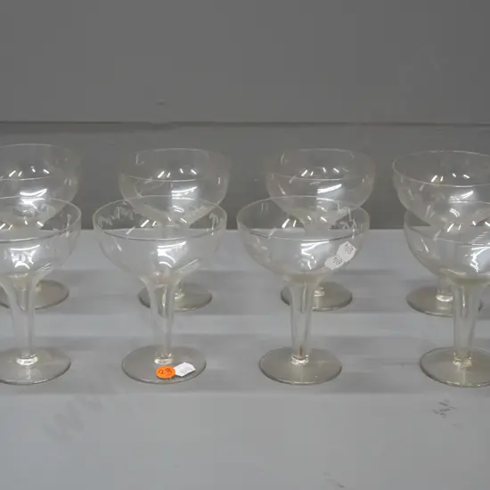 8 hollow-stem champagne glasses with etched pattern around bowls - some with grape motif, some bamboo and leaf pattern,