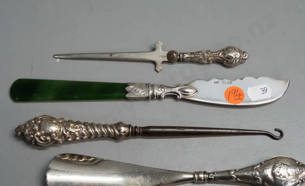 6 cutlery items, 4 hallmarked sterling silver, one knife with greenstone handle, plated sugar tongs and Dutch spoon. Image 1++