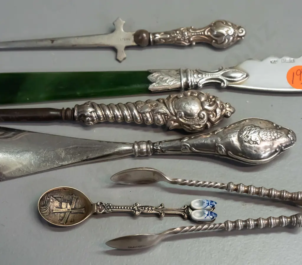 6 cutlery items, 4 hallmarked sterling silver, one knife with greenstone handle, plated sugar tongs and Dutch spoon. Image 1++