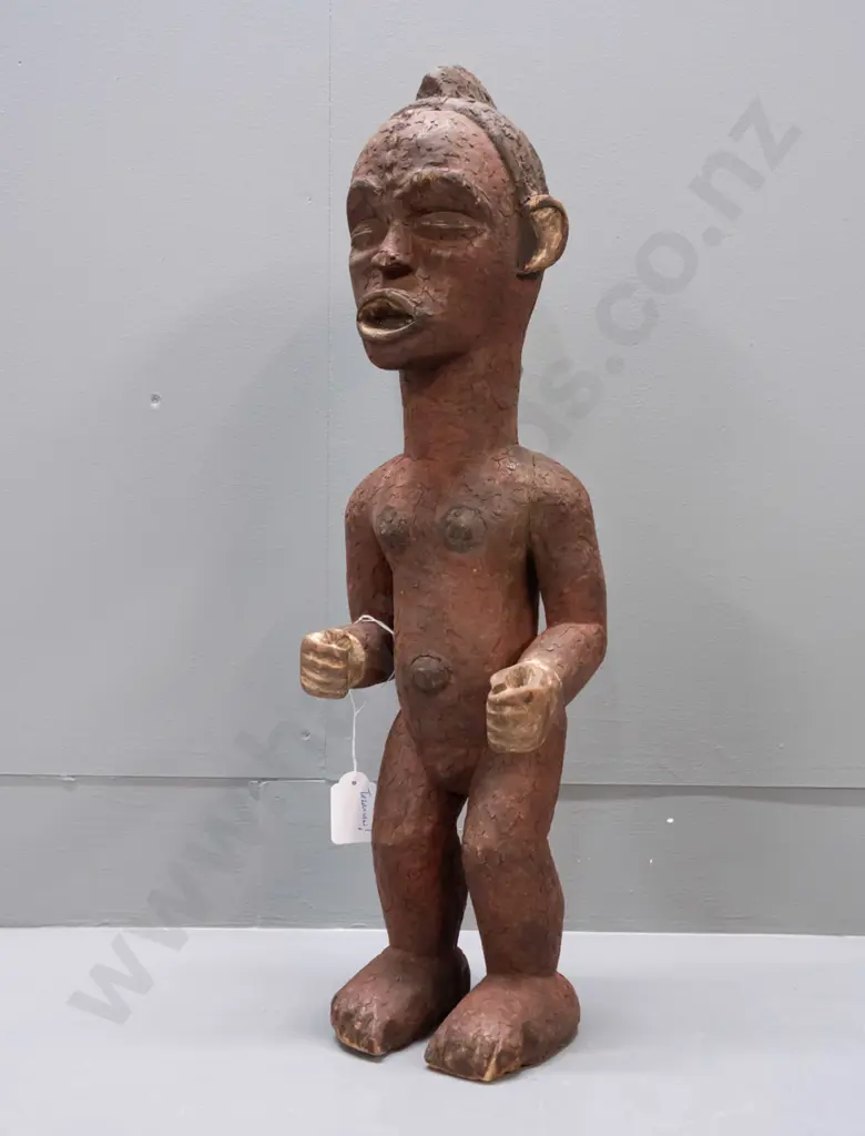 African carved wood standing figure, possibly Tanzania, coloured with earth pigments. Crack / repair to one arm, crazing Image 1++