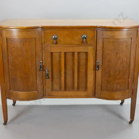 oak sideboard with 2 bowed cupboard doors, central drawer lined with felt, over cupboard door, metal drop handles,