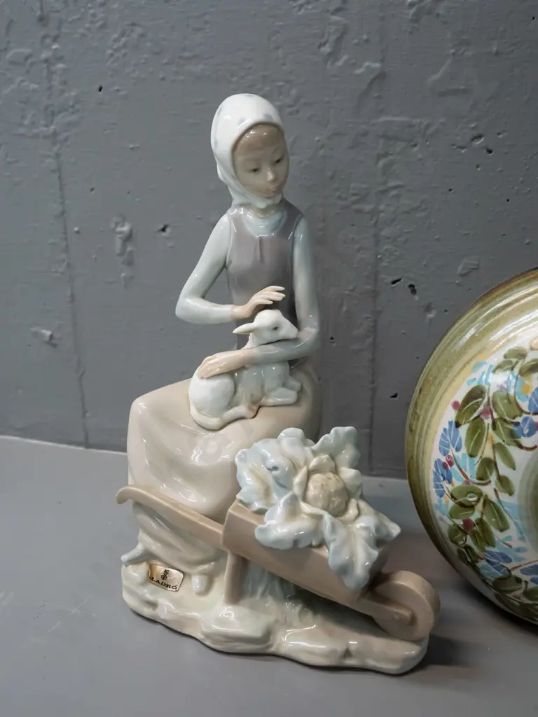 Lladro figurine - woman with lamb and wheelbarrow H-230 and a Greek pottery flask with ring handle and cork stopper. Image 1++