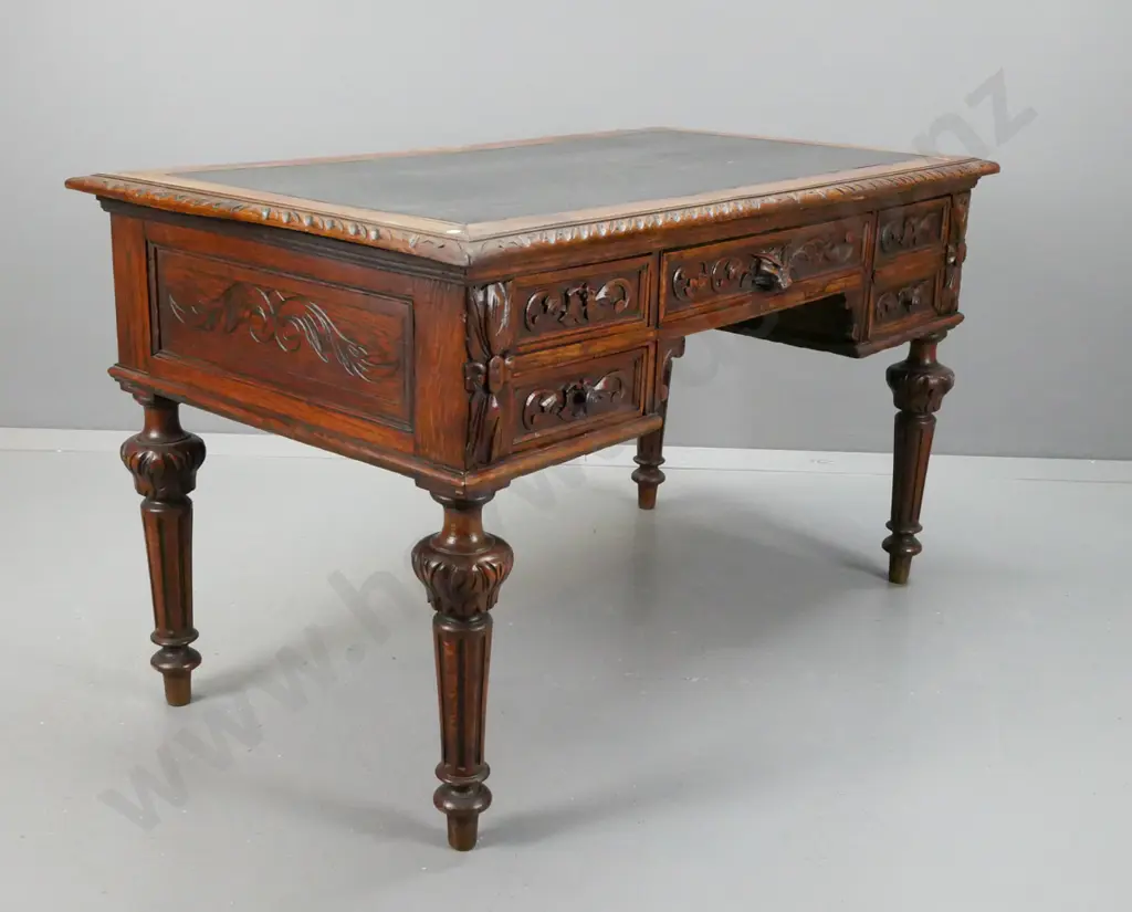 19th century French carved oak desk with carved edge top & drawer fronts, lion's head drawer, fluted and carved legs. Image 1++