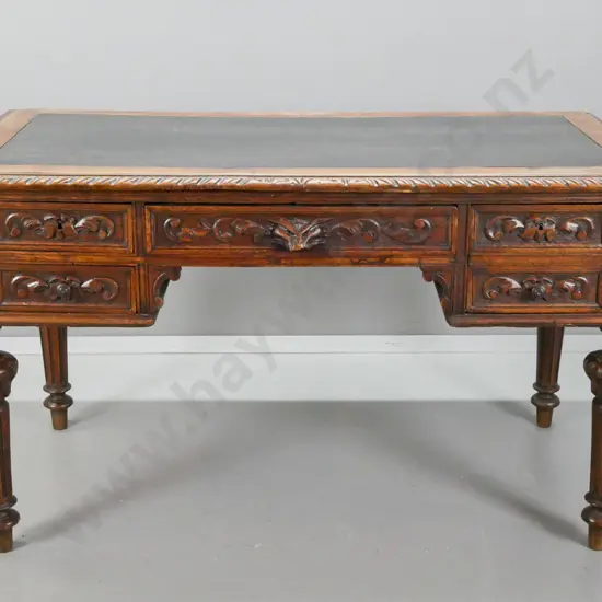 19th century French carved oak desk with carved edge top & drawer fronts, lion's head drawer, fluted and carved legs.